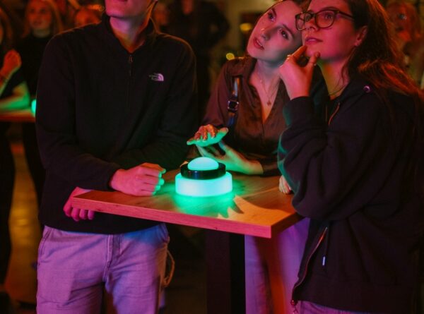 Drei Freunde denken über Quizfrage im Quizloft Siegburg nach