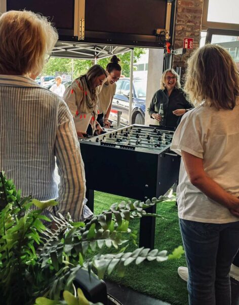 Frauen spielen Kicker und lachen dabei