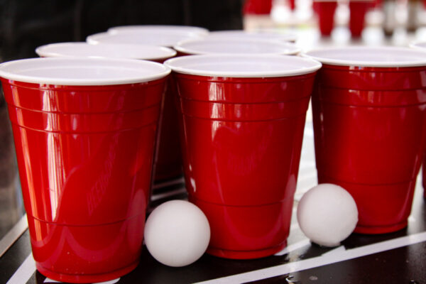 Rote Beerpong Becher und zwei Bälle