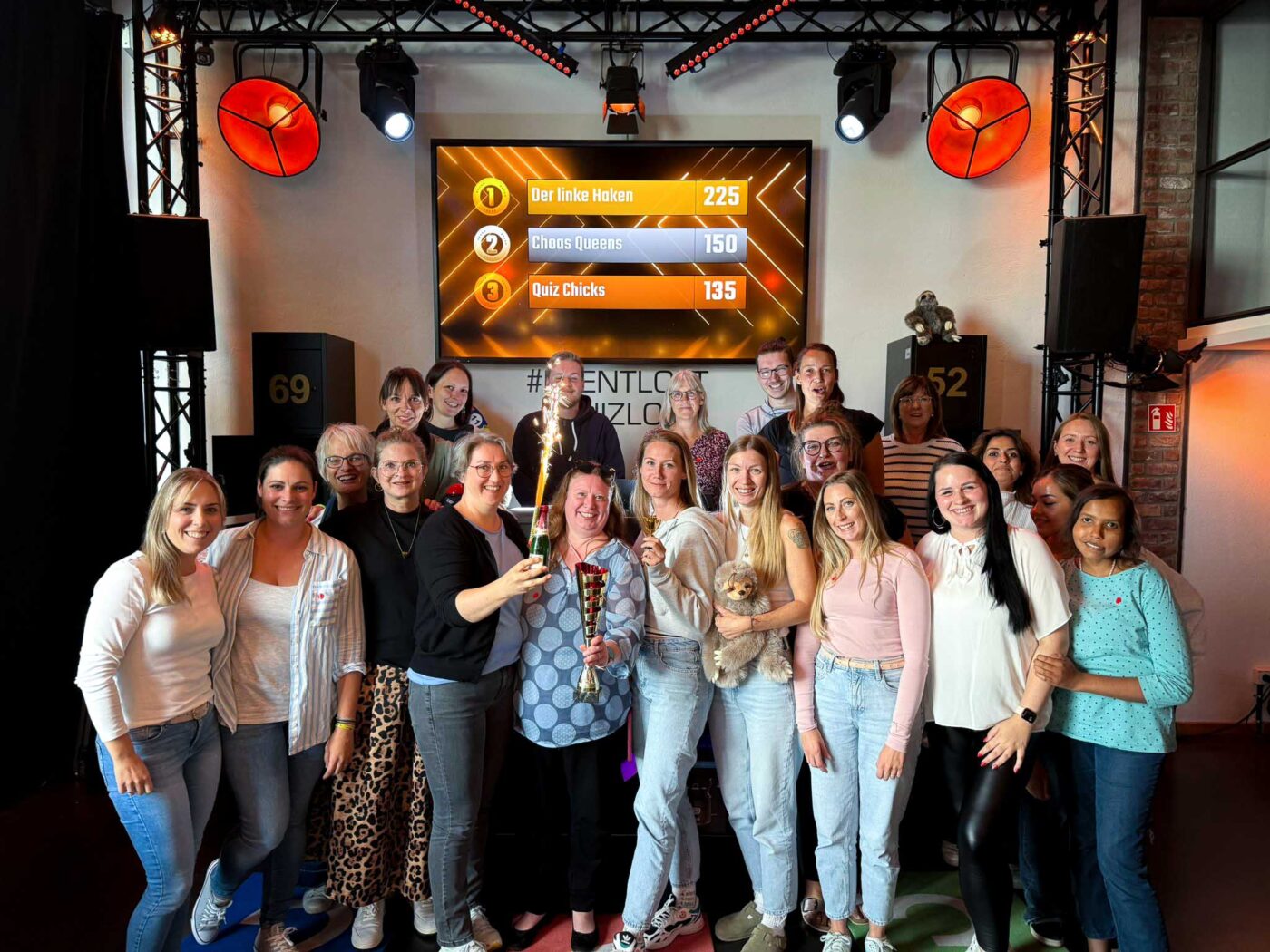 Siegerteam einer Show steht zusammen im Quizloft