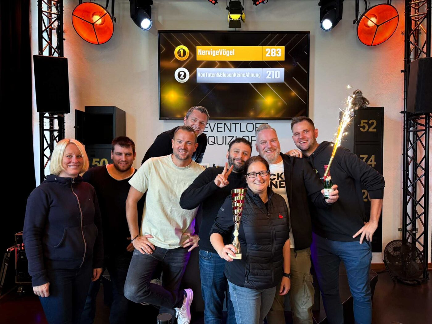 Siegerteam einer Show steht zusammen im Quizloft